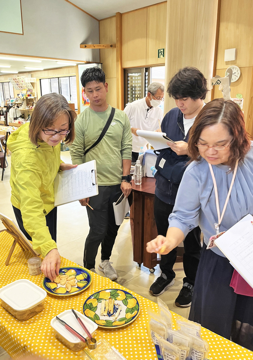 商品を試食し、味や見た目、話題性などを評価する審査員ら＝24日、鹿児島県宇検村（提供写真）