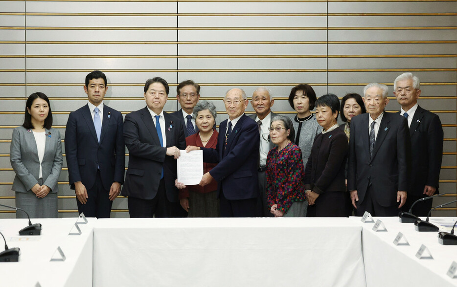 特定失踪者家族会の今井英輝会長（前列中央）から要望書を受け取る林芳正官房長官（左から３人目）＝１９日午後、首相官邸