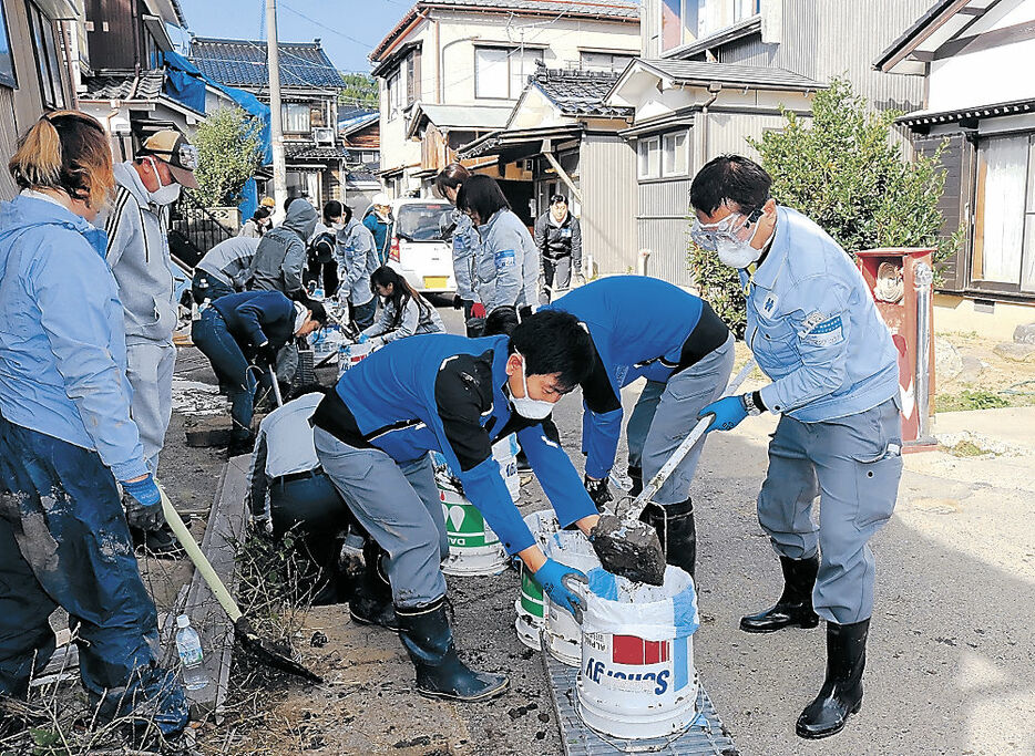 泥かきボランティア活動に取り組む北陸電力グループの社員＝１１日、輪島市内