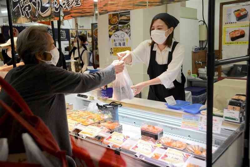 鶴屋百貨店で始まった「大道産子市」で海鮮弁当を購入する買い物客＝1日、熊本市中央区