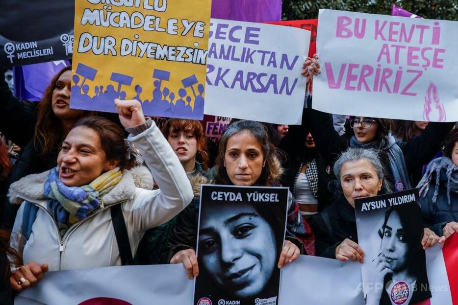 トルコ・イスタンブールで、「女性に対する暴力撤廃の国際デー」のデモ行進に参加し、男に殺害された娘の写真を掲げる女性（中央、2024年11月25日撮影）。【翻訳編集】 AFPBB News