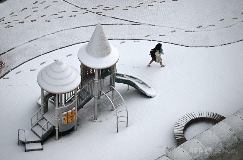 韓国高陽で、雪に覆われた公園を歩く学生（2024年11月27日撮影）。【翻訳編集】 AFPBB News