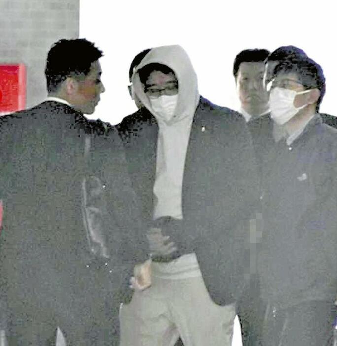 逮捕された西田容疑者（中央）（13日午前、福岡市城南区の福岡県警城南署で）＝画像の一部を修整しました