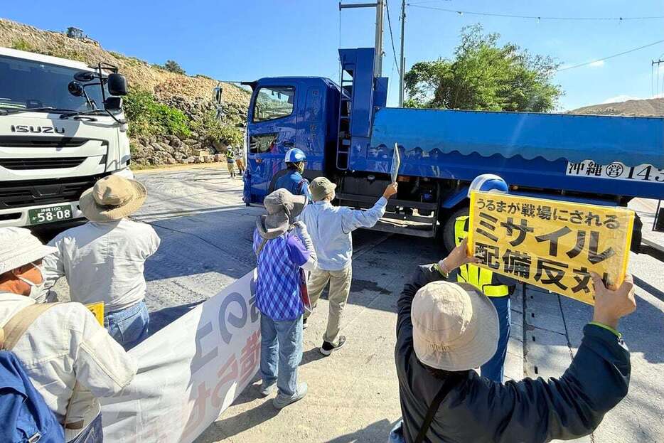 ダンプカーに向かってプラカードを掲げる人々＝27日、沖縄県うるま市（大竹直樹撮影）