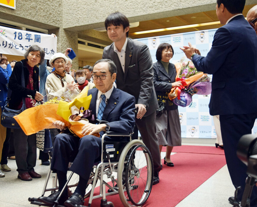 盛大な拍手を送られながら、家族と庁舎を後にする岩倉市長＝５日午前１１時２０分ごろ