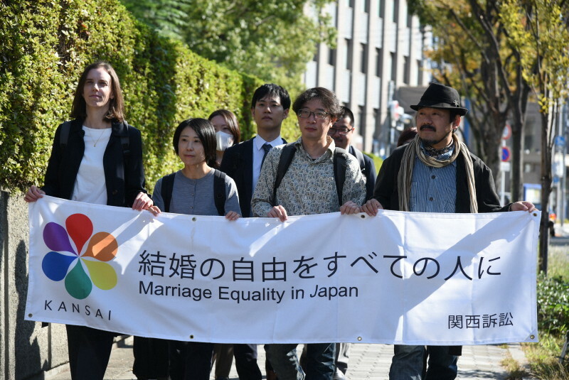 「結婚の自由をすべての人に」と書かれた横断幕を手に、大阪高裁に入る原告ら＝大阪市北区で2024年11月13日午前10時33分、土田暁彦撮影