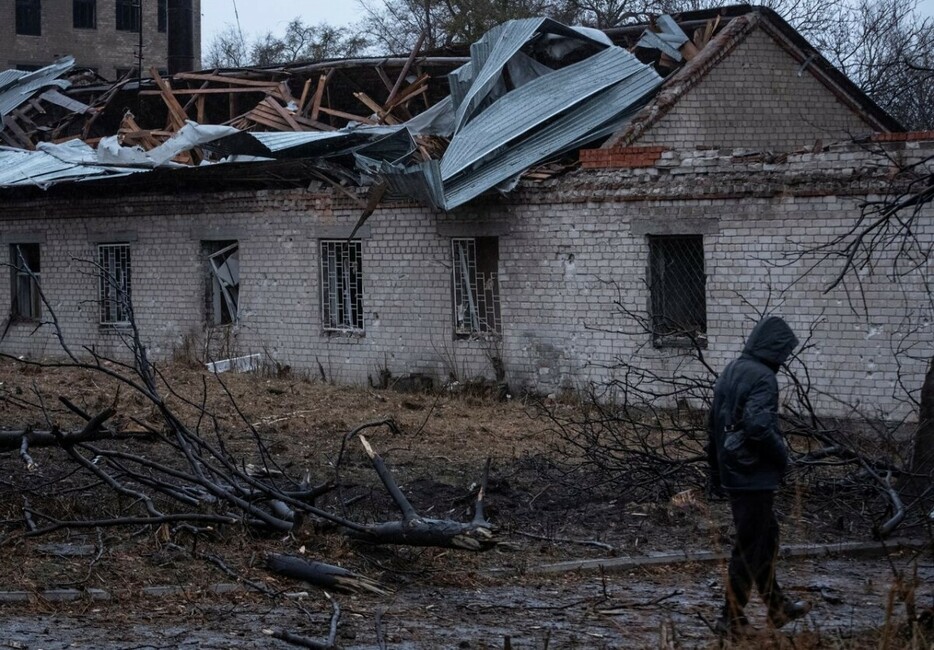 ロシアのミサイル攻撃を受けた場所を歩く住民＝２１日、ウクライナ東部ドニプロ