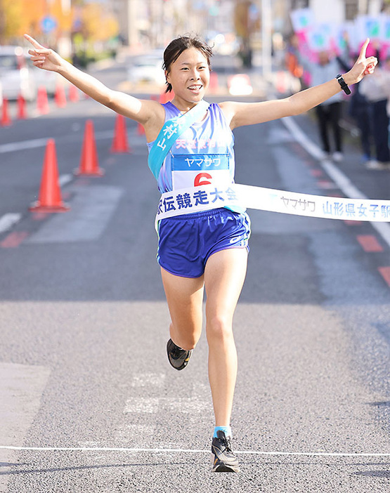 後続に23秒差を付けてゴールテープを切る天童・東村山のアンカー本間栞（山形中央高）＝山形市・山形メディアタワー前