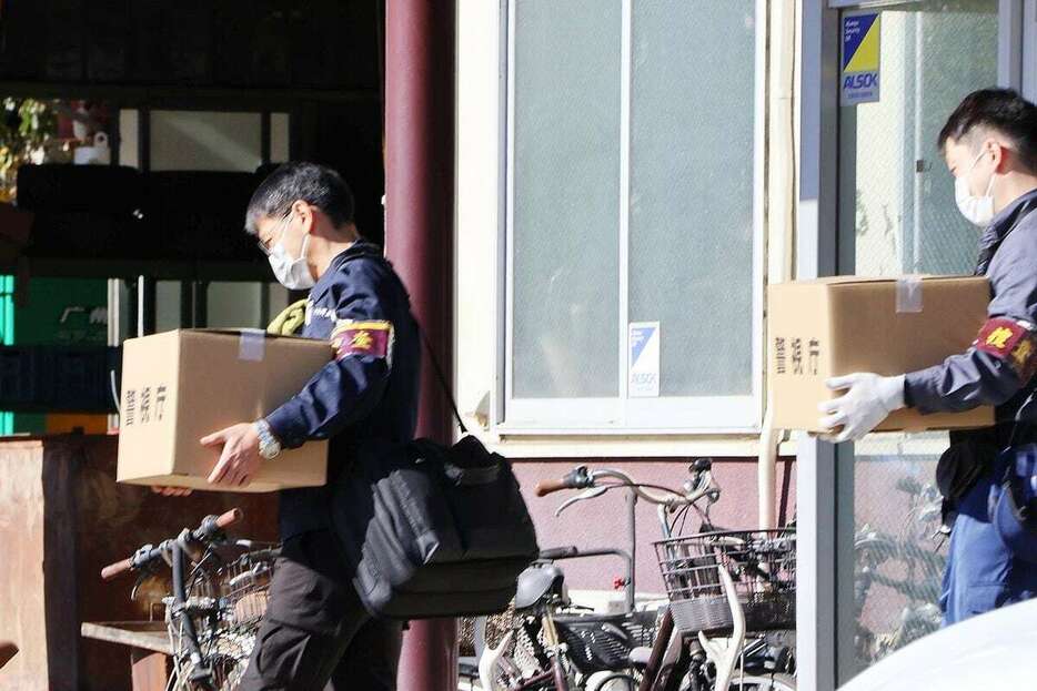 家宅捜索に入った金属買い取り会社から押収した資料を車両に入れる捜査員ら＝18日午後、栃木県小山市（梶原龍撮影）