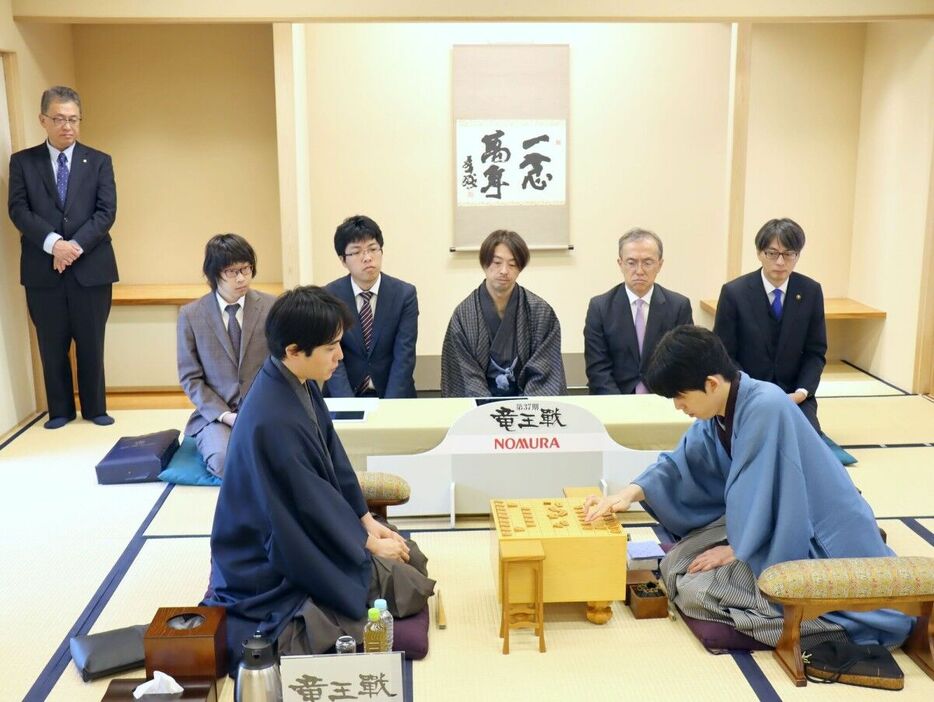 盤上に駒を並べる藤井聡太竜王（右）と挑戦者・佐々木勇気八段（日本将棋連盟提供）