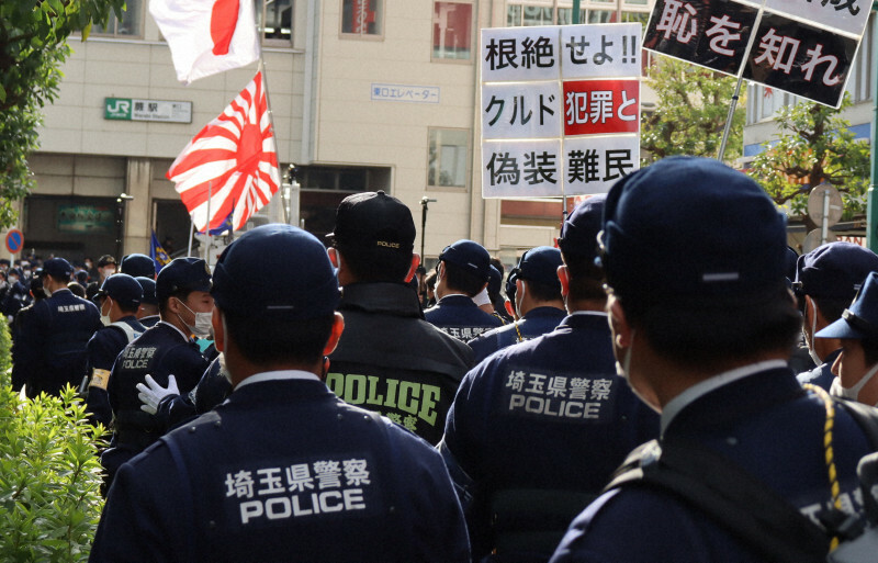 在日クルド人の排除を主張するデモの周囲で警備に当たる埼玉県警の警察官ら＝埼玉県蕨市で2024年2月18日、田原拓郎撮影