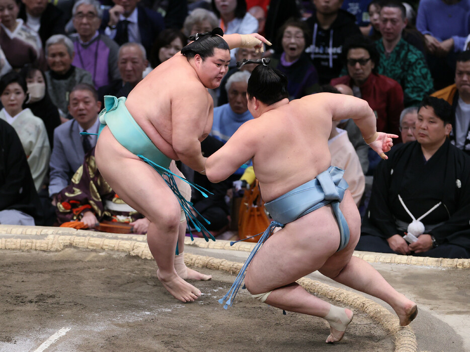 大相撲九州場所９日目。琴桜（左）は欧勝馬を押し倒しで下し、勝ち越しを決める＝１８日、福岡国際センター