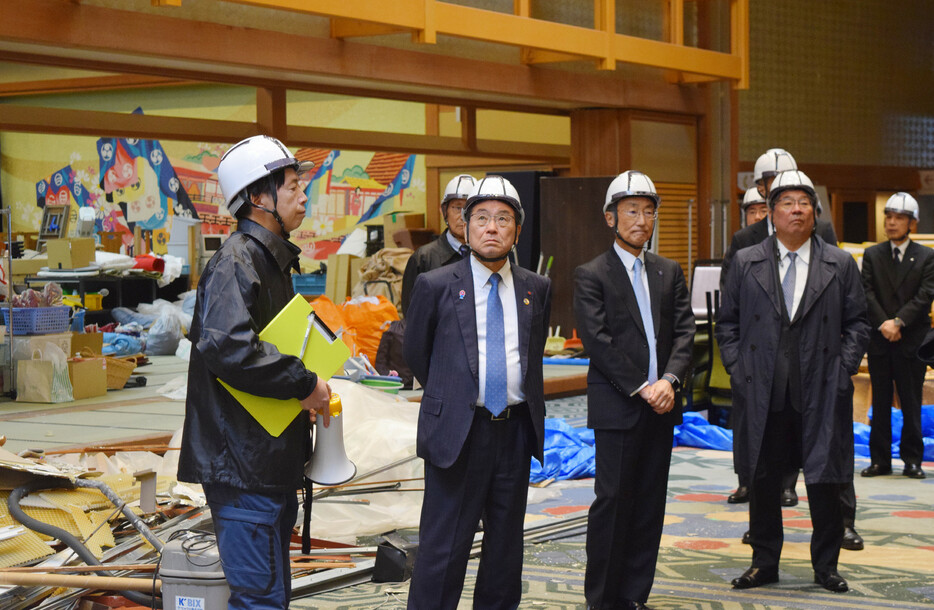 経団連は２０日、１月の地震と９月の豪雨で大きな被害を受けた石川県能登半島の被災地を視察した。写真は、休業中の七尾市内のホテルを視察する十倉雅和会長（左から２人目）ら＝同日午後