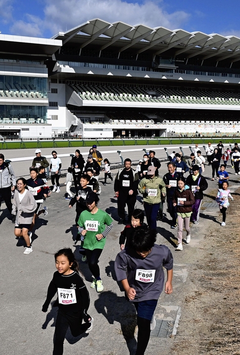 中京競馬場を走る家族連れら