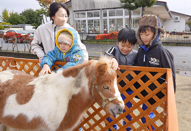 馬とふれ合う寒河江校の児童ら＝寒河江市・高松小グラウンド