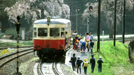 岩手開発鉄道の気動車キハ301。桜咲くなか通学の子どもたちが乗り込む（撮影：南正時）