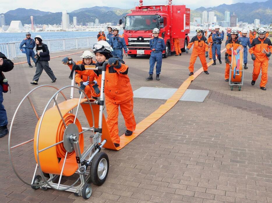 大量の海水を送るホースを設置する消防隊員ら＝ポーアイしおさい公園