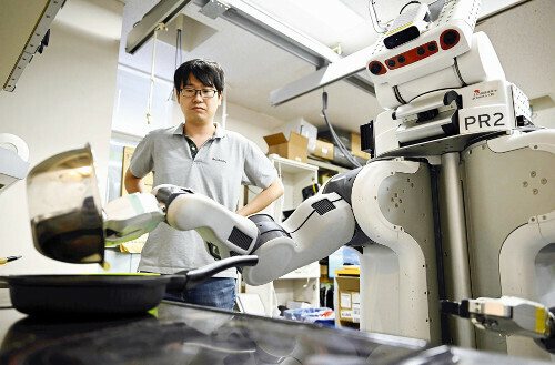 東京大の河原塚健人・特任助教が見守る中、目玉焼きを作る人型ロボット（９月１０日、東京都文京区で）＝帖地洸平撮影