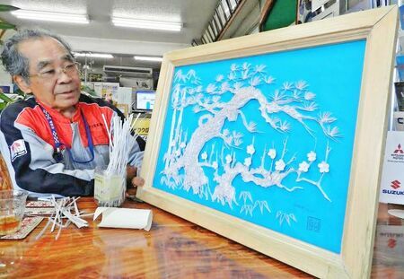 完成した「松竹梅」の額絵を眺める宮良祐次さん＝１０月２２日、石垣市登野城のロータス宮良自動車