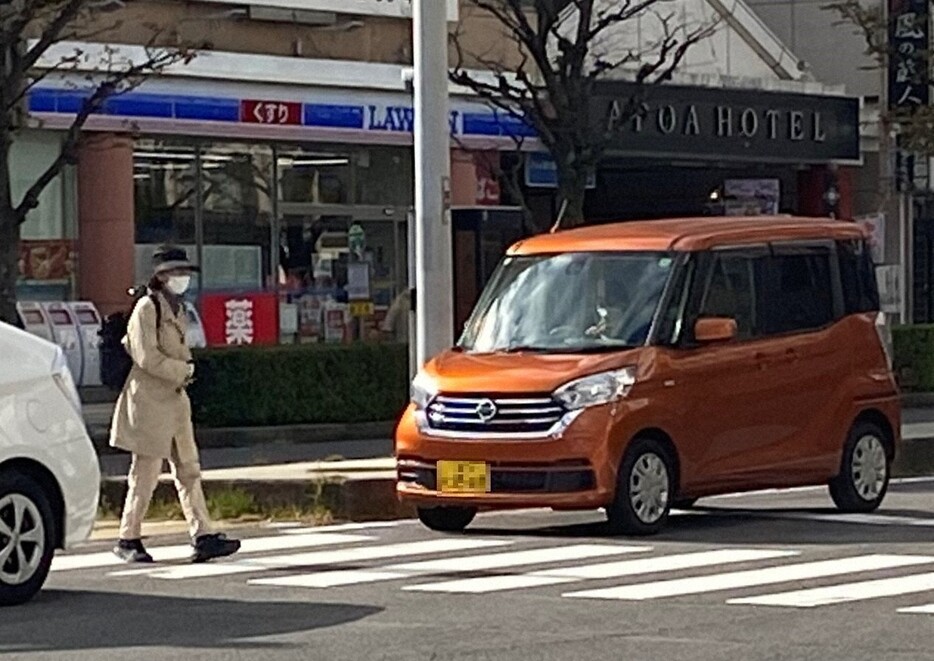 信号機のない横断歩道を渡る歩行者と一時停止する車＝津市栄町の津駅前で2024年11月28日午後0時18分、渋谷雅也撮影