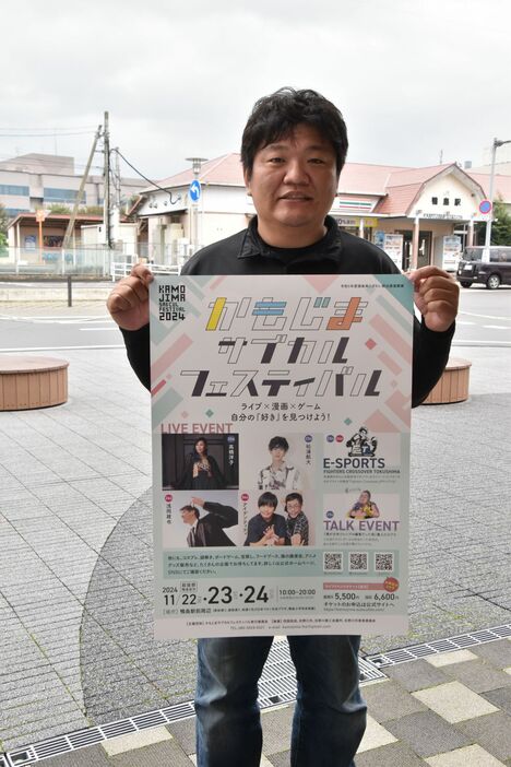 イベントの告知ポスターを手に来場を呼びかける西岡さん=吉野川市鴨島町の鴨島駅前イベント広場