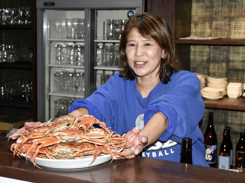 居酒屋「復興酒場」で香箱ガニを提供する松下直子さん＝石川県輪島市