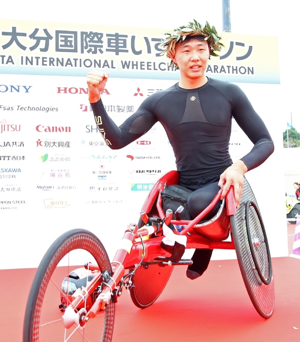 マラソンT34／53／54男子で初優勝を果たし、ガッツポーズをする金華＝17日、大分市西浜のジェイリーススタジアム