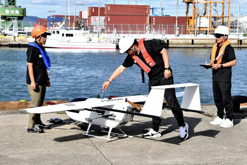 実証飛行の合間に大型ドローンを調整する担当者ら（１０月３０日、高松港で）