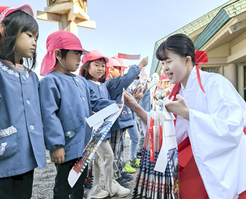 【千歳飴を受け取り笑顔を見せる園児ら＝伊勢市二見町江の二見興玉神社で】