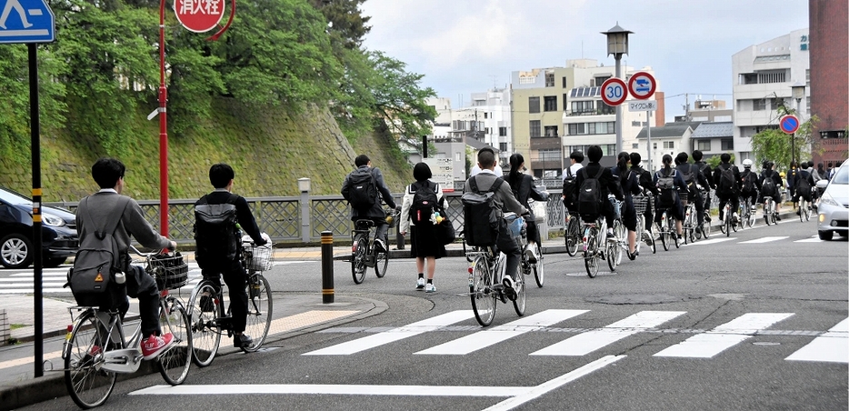 自転車で通学する高校生ら。ヘルメットを着用している生徒は少ない＝4月、福井県福井市大手2丁目