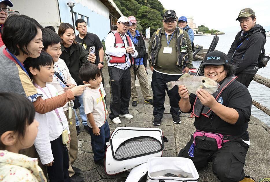 一般客に釣果を披露する参加者＝沼津市の「あわしまマリンパーク」