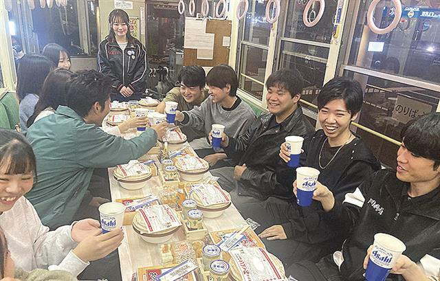 車内で乾杯する大学生ら