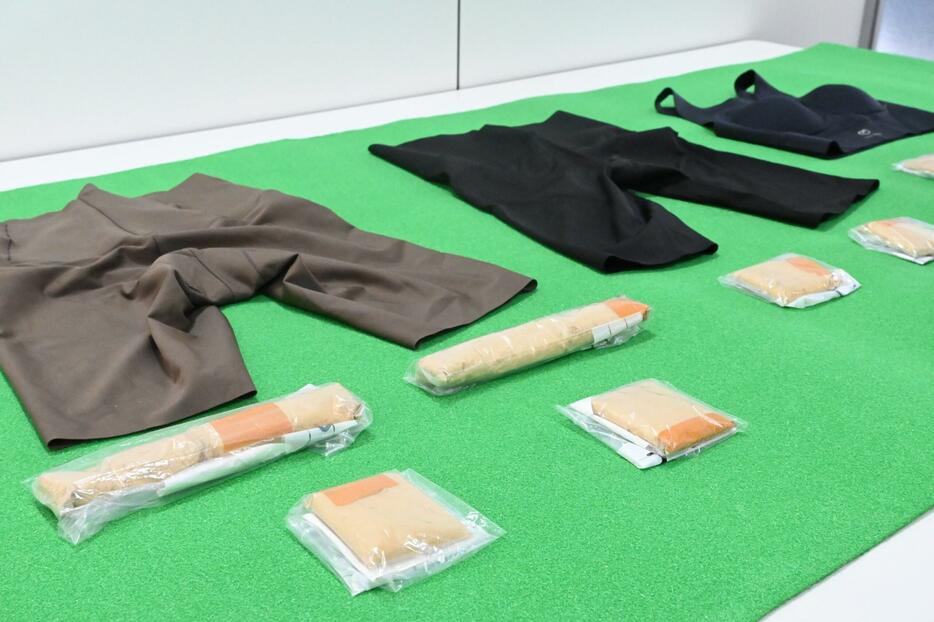 クルーズ船の乗客が着用していた衣服（奥）から見つかった金を含む粉末（手前）＝18日、那覇市若狭の那覇クルーズターミナル