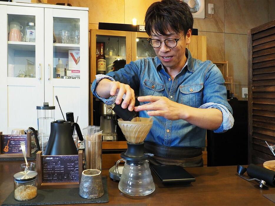 ひいたコーヒー豆をドリッパーにセットする田尾さん