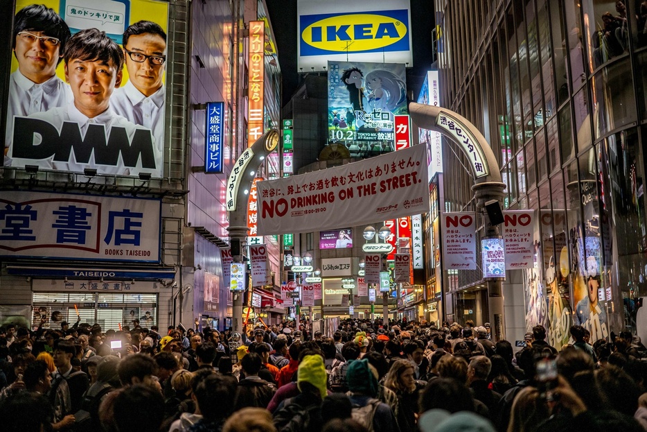 人であふれるハロウィーンの渋谷に掲げられた路上飲酒禁止を伝える横断幕や旗（2024年10月31日撮影）。【翻訳編集】 AFPBB News