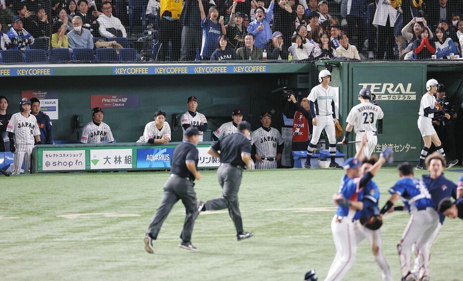 決勝で敗れ、厳しい表情で喜ぶ台湾ナインを見つめる井端監督（左から４人目）ら