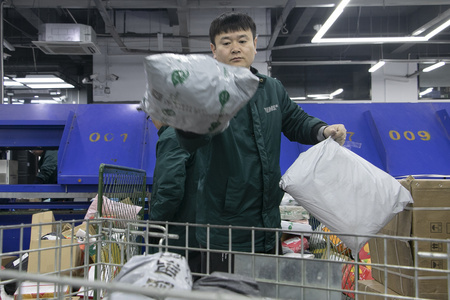 荷物の仕分けをする宅配仕分けセンターの作業員（2024年2月8日撮影、資料写真）。