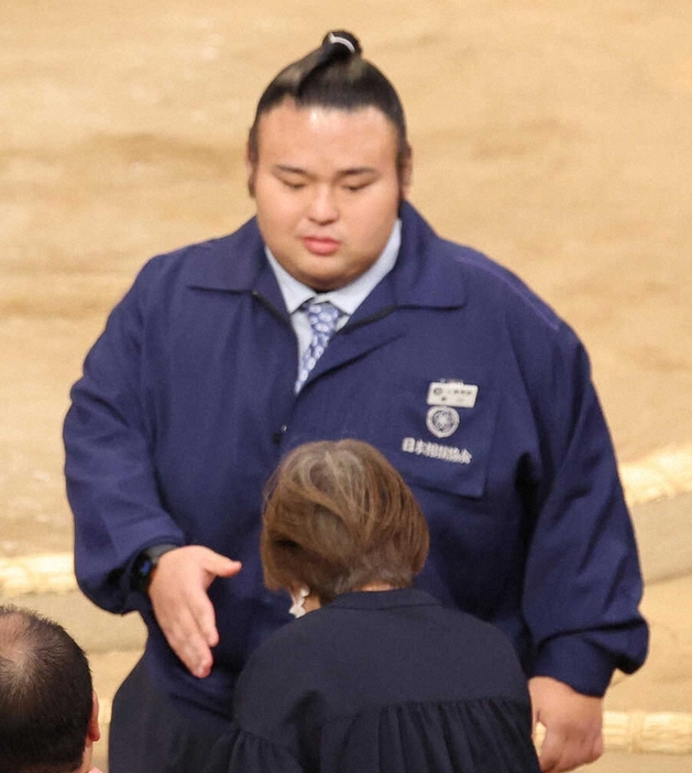 ファンと握手する元大関・貴景勝の湊川親方（撮影・成瀬　徹）　　