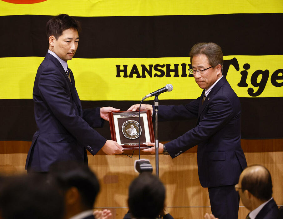 若林忠志賞を受賞し、粟井社長（右）から表彰を受ける阪神岩崎（撮影・藤尾明華）