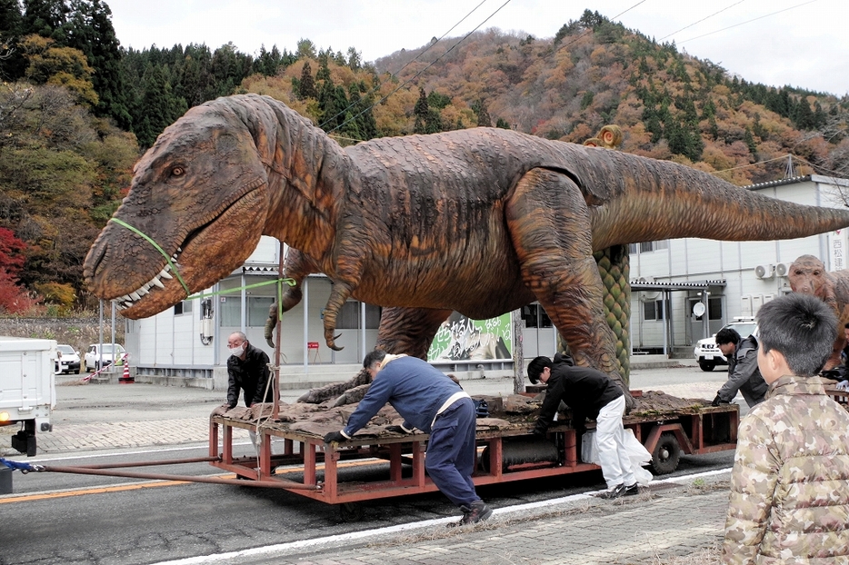 住民に見守られながら倉庫に〝引っ越す〟恐竜のモニュメント＝11月26日、福井県大野市朝日