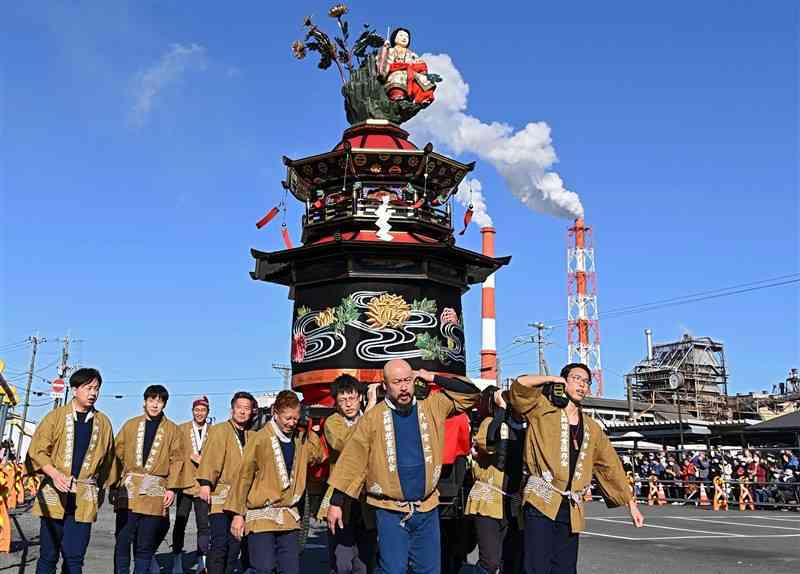 八代駅前を進む笠鉾「菊慈童」＝23日、八代市（石本智）