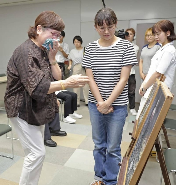 浦川結衣さん（左から２人目）が制作した絵画に涙を見せる森律子さん＝２０２４年７月、福岡市