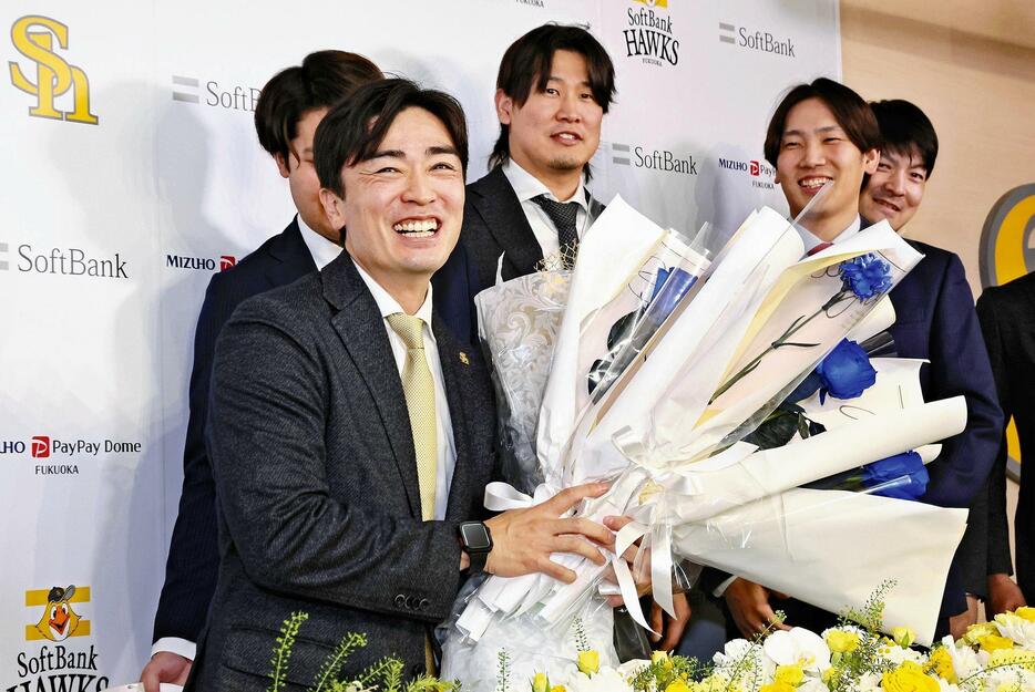 記者会見後、選手らからの花束を手に笑顔を見せる和田（左手前）＝佐伯文人撮影