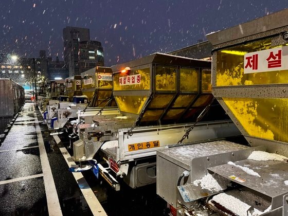 全国的に大雪が降った１１月２７、２８日、京畿道高陽市徳陽区（ドクヤング）庁の駐車場で非常待機中の除雪車。晩秋から初春までの４カ月半の間、除雪関連の勤労者はコンテナ（写真左）を出入りする。今回の大雪でも２６日午後から２８日午後まで４８時間ほど待機した。　キム・ホンジュン記者