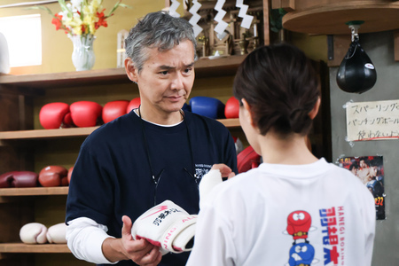 初心者のほこ美を歓迎し、成長を見守る優しい羽根木会長。©︎TBS