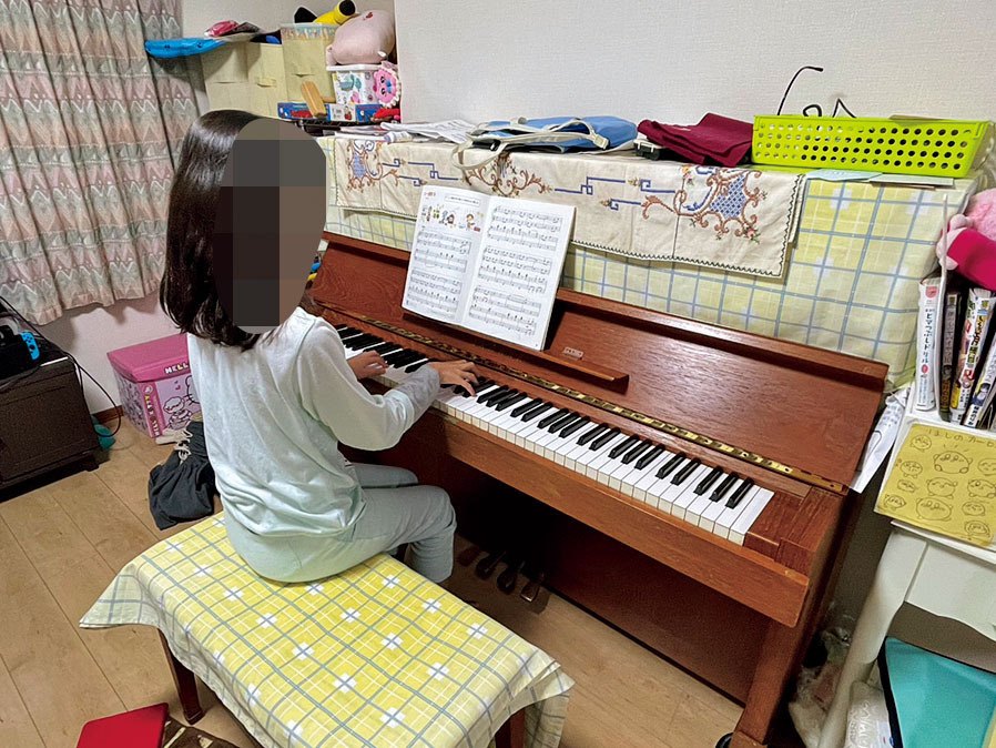 習っているピアノを弾く伊東さんの娘。だが、公立小学校6年生の学校外活動費は平均10万6979円と、家計の重荷