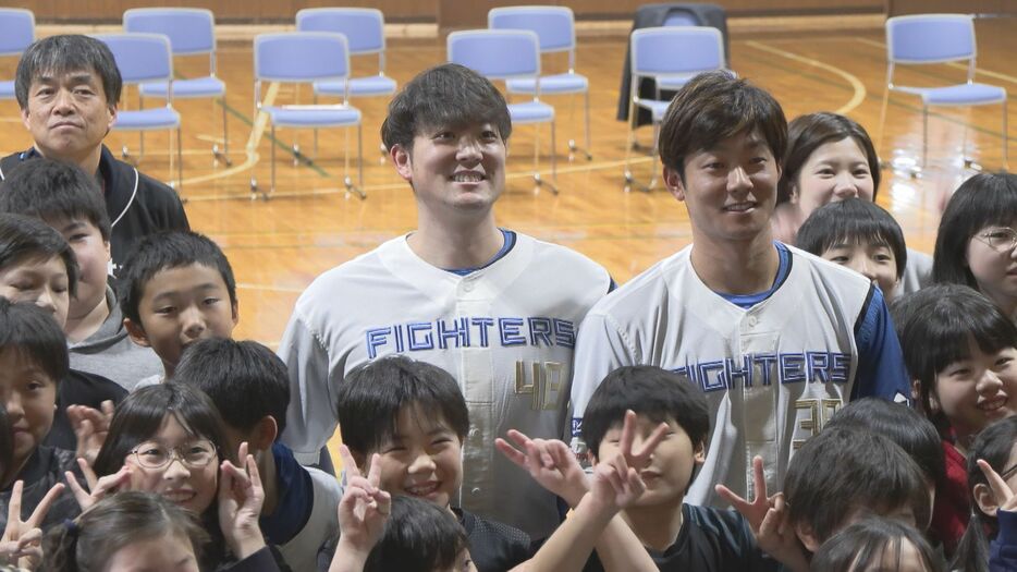 小学生と交流をする斎藤投手と石井選手