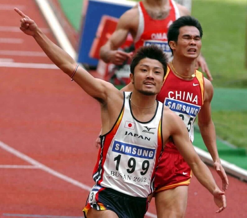 アジア大会陸上・男子200㍍決勝で優勝し、指を突き上げる末続慎吾＝2002年