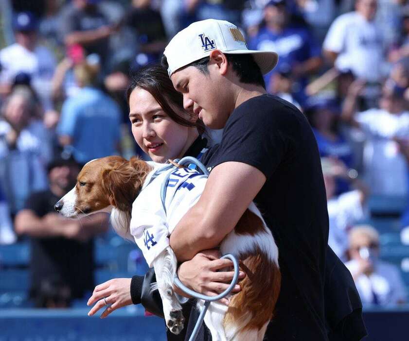 愛犬のデコピンを抱きかかえる大谷翔平。奥は真美子夫人