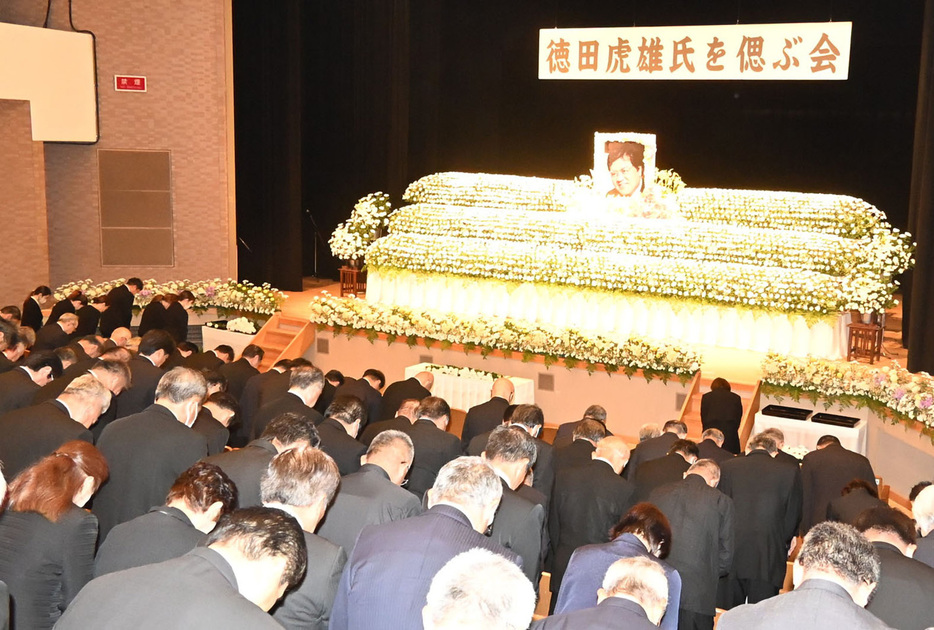 偲ぶ会で祭壇に向かい拝礼する参加者＝12日、鹿児島県徳之島町の文化会館